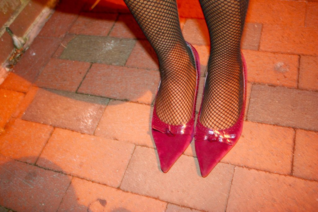 Burgundy pumps and fishnet tights