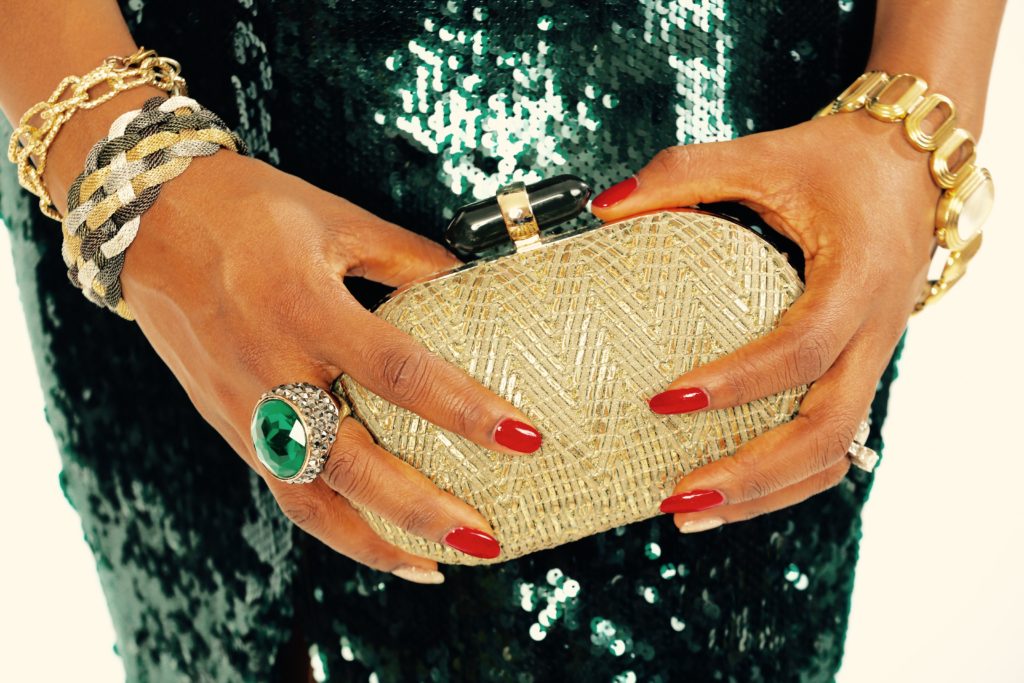 Gold clutch with green cocktail ring and DG watch