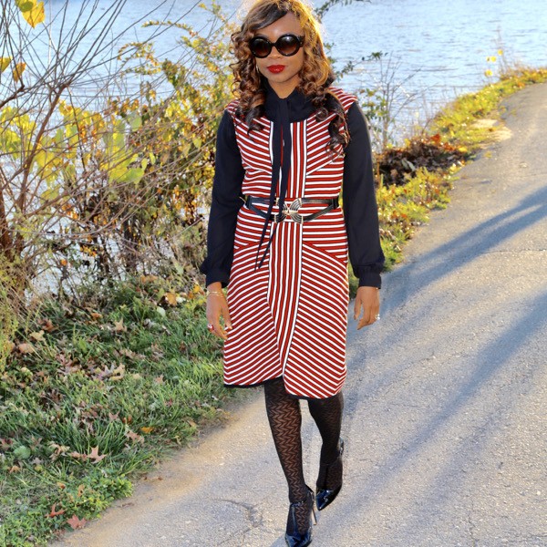 belted sleeveless knit dress layered with black blouse